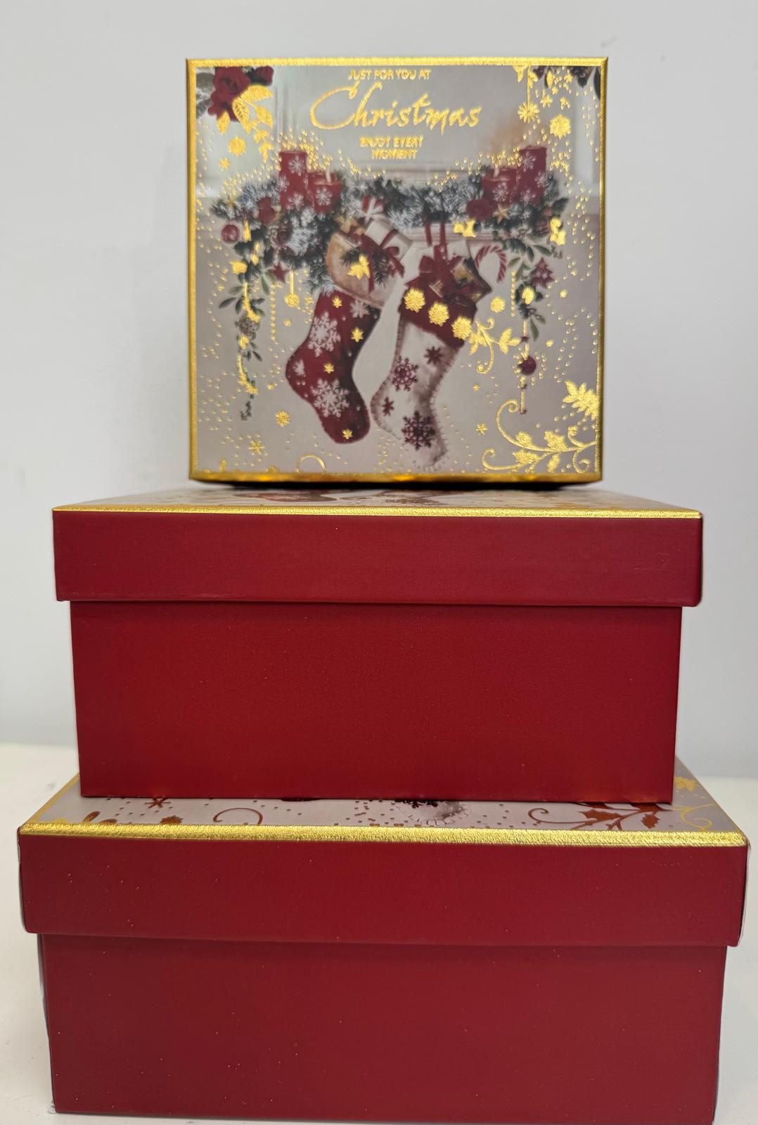 Stacked red Christmas gift boxes with stocking design lid